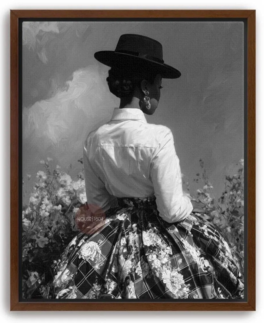 A woman wearing a hat and a white blouse stands in front of a field of flowers, facing away from the camera.