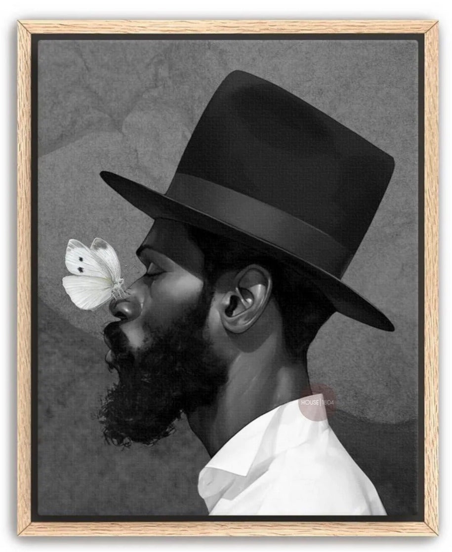 A black and white portrait of a man with a large hat, a long beard, and a butterfly resting on his nose.