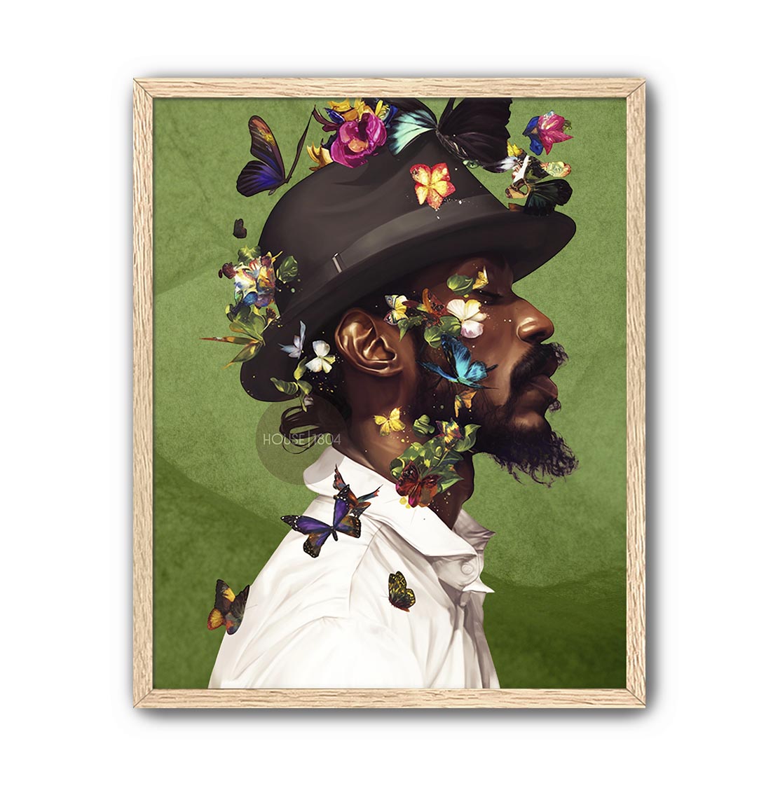 A man wearing a hat adorned with colorful butterflies and flowers, surrounded by a lush green background.