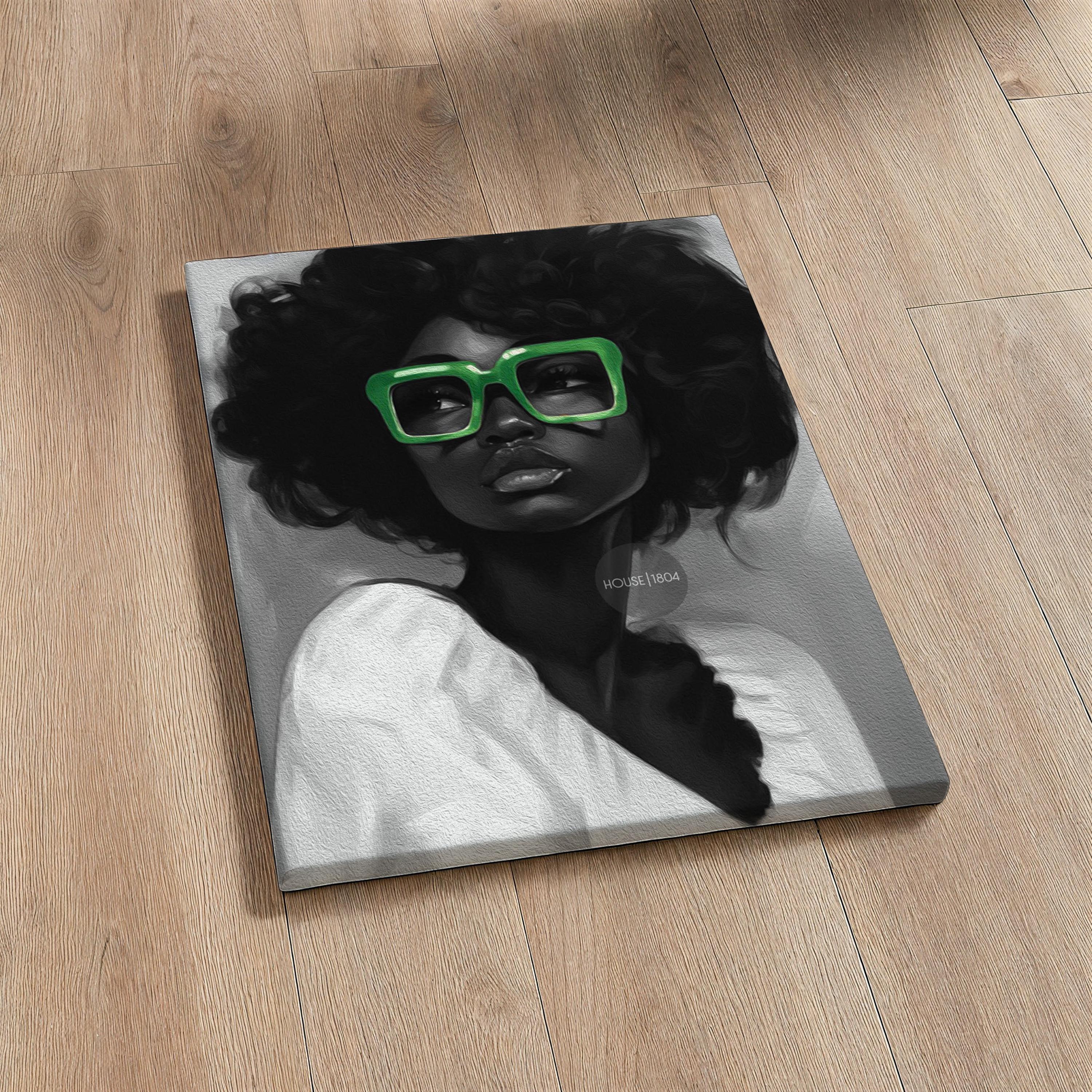 A black and white portrait of a Black woman with curly afro hair wearing large bold green reading glasses. Stretched canvas print.