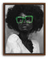 A black and white portrait of a Black woman with curly afro hair wearing large bold green reading glasses. Brown framed canvas print.