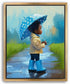 A young child in a yellow raincoat and blue rain boots stands on a wet path, holding a blue umbrella with white polka dots.
